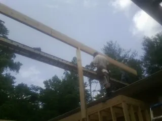 Carpenter setting a ridge beam over a new addition frame — Ice Dam Removal by Roofing Brothers in Richards