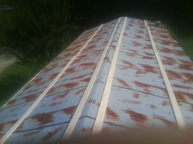 Rusted metal roof panels with new wood purlins before replacement — Storm Damage Roof Repair in Richards by Roofing Brothers